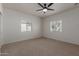 Bright, carpeted bedroom featuring two windows and neutral walls at 5635 S 11Th Dr, Phoenix, AZ 85041