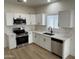 Well-lit kitchen featuring stainless steel appliances, white cabinets, and elegant marble countertops at 5635 S 11Th Dr, Phoenix, AZ 85041