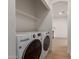 Modern laundry room featuring new, front loading washer and dryer, plus a convenient folding shelf at 5635 S 11Th Dr, Phoenix, AZ 85041
