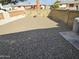 A backyard gravel area, accented with sculptures, enclosed by a textured brick wall, providing a peaceful outdoor space at 5728 E Dodge St, Mesa, AZ 85205
