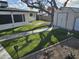 This backyard features artificial grass and a quaint storage shed, perfect for outdoor enjoyment at 5728 E Dodge St, Mesa, AZ 85205