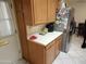 Functional kitchen area with wood cabinets and modern stainless steel refrigerator at 5728 E Dodge St, Mesa, AZ 85205