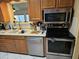 Functional kitchen with stainless steel appliances, wood cabinets, and tiled backsplash at 5728 E Dodge St, Mesa, AZ 85205