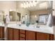 Bathroom featuring double sinks with wood cabinets, ample countertop space, and large mirrors at 5735 S Cloverdale Ln, Gilbert, AZ 85298