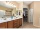 Bathroom featuring double sinks with wood cabinets, ample countertop space, and large mirrors at 5735 S Cloverdale Ln, Gilbert, AZ 85298
