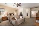 Spacious bedroom with comfortable seating area, ceiling fan, ensuite, and natural light at 5735 S Cloverdale Ln, Gilbert, AZ 85298