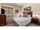 Bedroom with wood dresser, nightstands, a large window, and carpet flooring at 5735 S Cloverdale Ln, Gilbert, AZ 85298
