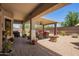 Inviting covered patio featuring a cozy seating area and a charming stone fire pit at 5735 S Cloverdale Ln, Gilbert, AZ 85298