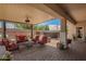 Relaxing covered patio area with red cushioned seating and a view of the backyard at 5735 S Cloverdale Ln, Gilbert, AZ 85298