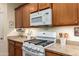 Close up of a well-maintained kitchen with granite countertops, white appliances, and wood cabinets at 5735 S Cloverdale Ln, Gilbert, AZ 85298