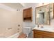 Standard bathroom features a bathtub and shower combination and wood vanity with framed mirror at 635 W Flower Ave, Mesa, AZ 85210