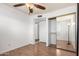 Spacious bedroom boasts wood-look floors, closet, ceiling fan, and open access to a hallway at 635 W Flower Ave, Mesa, AZ 85210