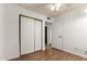 Bright bedroom features wood-look floors, ceiling fan, closet, and access to another room at 635 W Flower Ave, Mesa, AZ 85210