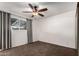 Carpeted bedroom with ceiling fan and window offering natural light at 635 W Flower Ave, Mesa, AZ 85210