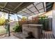 Covered hot tub area features a wooden deck and a shaded canopy structure at 635 W Flower Ave, Mesa, AZ 85210