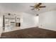 Open-concept living area leads into kitchen with carpet, tile flooring and ceiling fan at 635 W Flower Ave, Mesa, AZ 85210