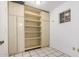 Storage room features a wall of built in shelves and cabinets, and tile flooring at 635 W Flower Ave, Mesa, AZ 85210