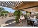 Cozy covered back patio with desert landscaping and a charming pergola for relaxed outdoor living at 6448 E Des Moines St, Mesa, AZ 85205