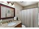 Cozy bathroom featuring granite counters, decorative mirror, and a shower with curtain at 6448 E Des Moines St, Mesa, AZ 85205