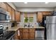 Well-lit kitchen featuring stainless steel appliances, granite countertops, and a window with a view at 6448 E Des Moines St, Mesa, AZ 85205