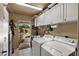 Functional laundry room with washer, dryer, and storage cabinets, conveniently located near the backyard entrance at 6448 E Des Moines St, Mesa, AZ 85205