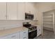 Bright kitchen with white cabinets, stainless appliances, quartz counters, and pantry at 6944 E Gary Cir, Mesa, AZ 85207