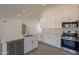 Kitchen island with white cabinets, modern appliances, quartz counters, and lots of natural light at 6944 E Gary Cir, Mesa, AZ 85207