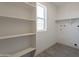 Bright laundry room includes built-in shelving and a window with natural light at 6944 E Gary Cir, Mesa, AZ 85207
