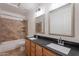 Bright bathroom with a double sink vanity, tiled shower and tub combo at 8158 E Rita Dr, Scottsdale, AZ 85255