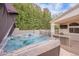 Relaxing hot tub next to an outdoor entertainment area and lush landscaping at 8158 E Rita Dr, Scottsdale, AZ 85255