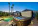 A luxurious hot tub and pool featuring palm trees and backyard landscaping at twilight at 8158 E Rita Dr, Scottsdale, AZ 85255