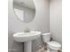A cozy half-bathroom with modern fixtures including a decorative oval mirror at 8208 W Albeniz Pl, Phoenix, AZ 85043