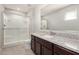 This bathroom features granite countertops, wood cabinets, and a walk-in shower at 8208 W Albeniz Pl, Phoenix, AZ 85043