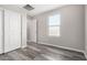 Clean bedroom features gray flooring, closet with white sliding doors, and natural light from window at 8208 W Albeniz Pl, Phoenix, AZ 85043