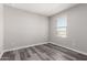 Bright bedroom with modern gray wood flooring and a window view of the landscape at 8208 W Albeniz Pl, Phoenix, AZ 85043