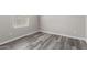 Bright bedroom with modern gray wood flooring and a window that allows in natural light at 8208 W Albeniz Pl, Phoenix, AZ 85043