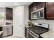 This kitchen has granite countertops, stainless steel appliances, and dark wood cabinets at 8208 W Albeniz Pl, Phoenix, AZ 85043