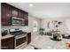 A bright kitchen is featured with stainless steel appliances and a breakfast nook dining area at 8208 W Albeniz Pl, Phoenix, AZ 85043
