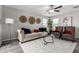 Bright living room featuring a neutral-toned sofa, armchairs, and stylish decor at 8208 W Albeniz Pl, Phoenix, AZ 85043