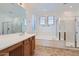 Bright bathroom with double sinks, a soaking tub, and a glass-enclosed shower at 8766 W Hayward Ave, Glendale, AZ 85305