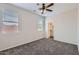 Bedroom featuring dual windows, carpet, ceiling fan, and an attached closet at 8766 W Hayward Ave, Glendale, AZ 85305