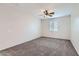 Cozy bedroom features neutral carpet, ceiling fan and bright window at 8766 W Hayward Ave, Glendale, AZ 85305