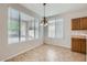 Bright dining area featuring tile flooring, a chandelier, and large windows with blinds at 8766 W Hayward Ave, Glendale, AZ 85305