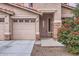 View of the home's front exterior with desert landscaping, a three-car garage, and a covered entry at 8766 W Hayward Ave, Glendale, AZ 85305