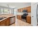Bright kitchen features stainless steel appliances, wood cabinets, and tile floors at 8766 W Hayward Ave, Glendale, AZ 85305