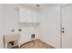 Functional laundry room offers white cabinets, tile floors, a utility sink, and access to the outdoors at 8766 W Hayward Ave, Glendale, AZ 85305
