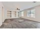 Spacious living room with neutral carpet, decorative built-in shelving, and natural light at 8766 W Hayward Ave, Glendale, AZ 85305