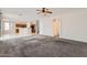 Open-concept living room features a ceiling fan and flows into the kitchen at 8766 W Hayward Ave, Glendale, AZ 85305