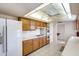 Bright kitchen with white appliances, wood cabinets, and a ceiling fan for added comfort at 10137 W Forrester Dr, Sun City, AZ 85351
