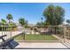 View of a lush backyard with a swimming pool, green lawn, and mature trees seen from an elevated deck at 10759 N 101St St, Scottsdale, AZ 85260